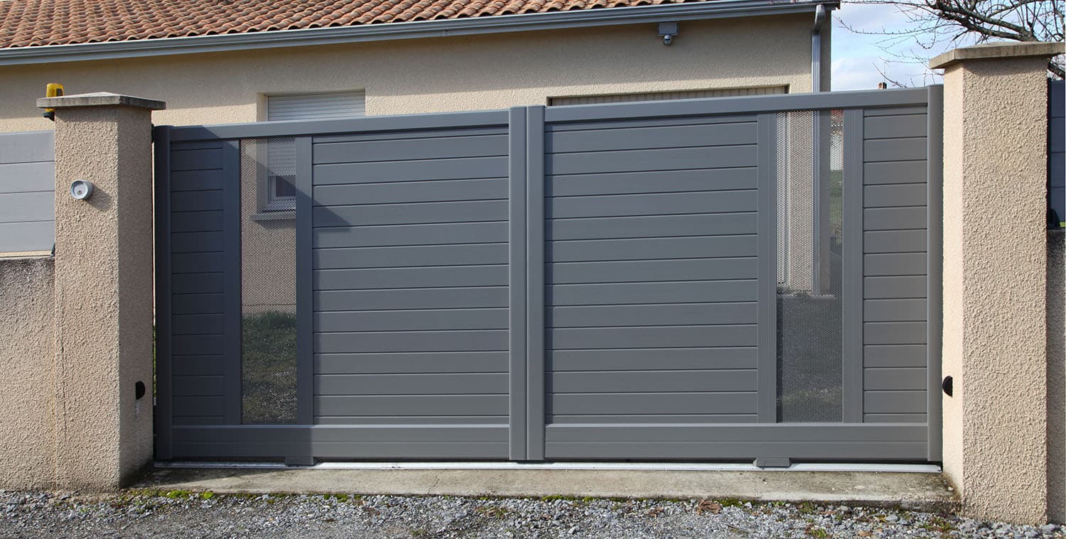 Portón corredizo moderno color gris antracita con diseño horizontal instalado en entrada residencial